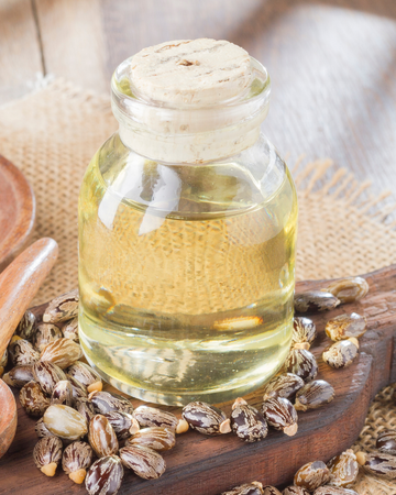Bouteille en verre ambré avec bouchon en liège, entourée de graines de fenouil